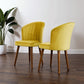 Modern yellow velvet accent chairs with wood legs in a minimalist living room setting