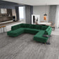 Modern living room with green sectional sofa, gray rug, open kitchen, and dining area