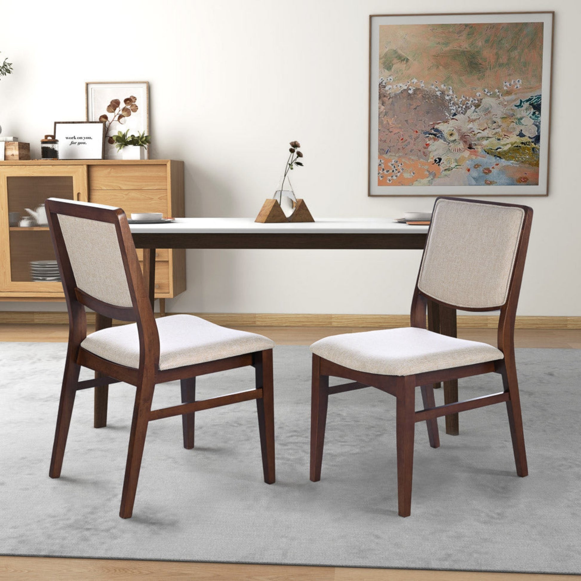 Modern dining room with two wooden chairs, a minimalist table, and neutral decor
