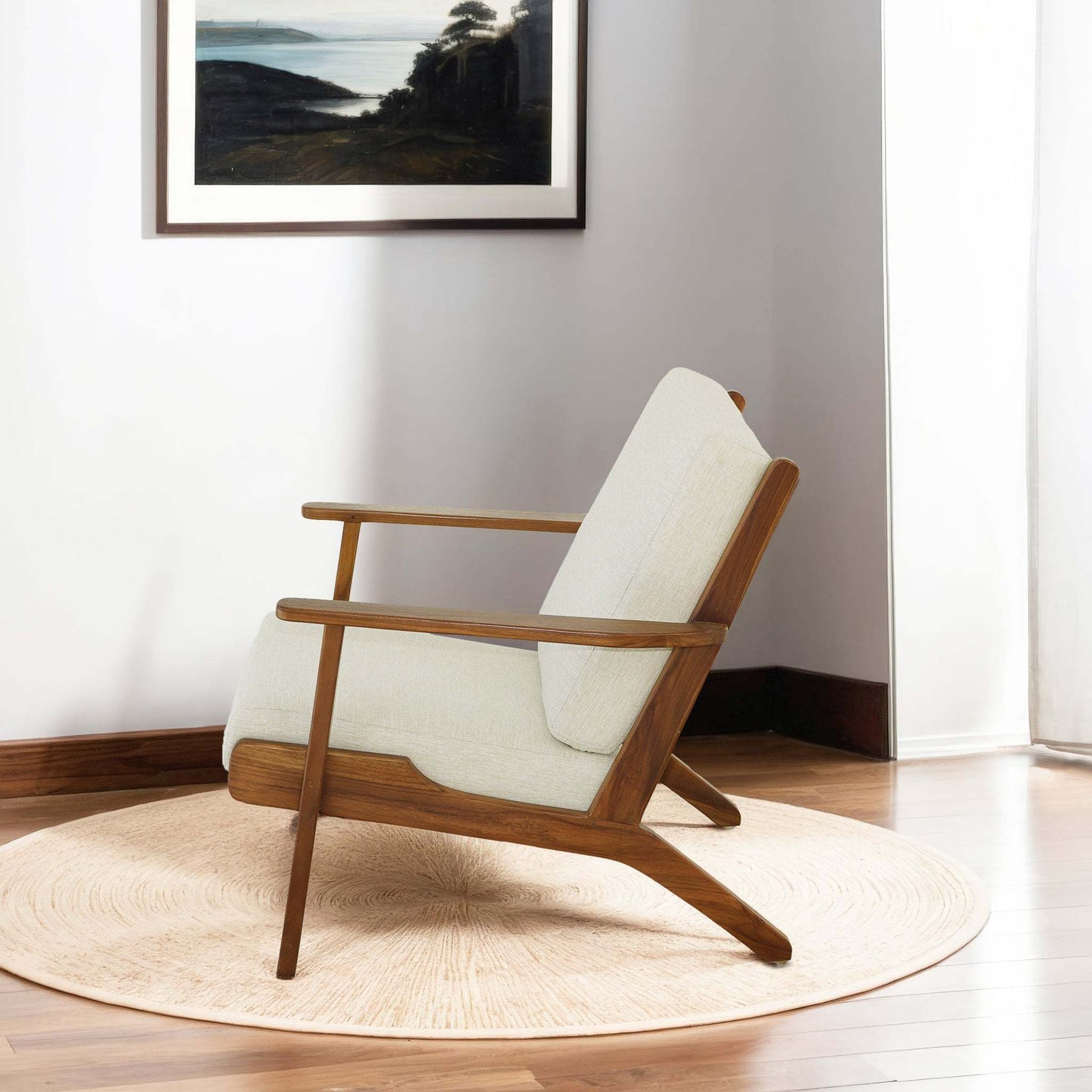 Mid-century modern armchair with light upholstery and wooden frame on round rug in sunlit room
