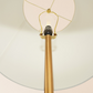 Close-up of modern gold floor lamp with white lampshade from FredCo International furniture