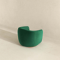 Modern green accent chair with curved back in minimalist room from FredCo International furniture