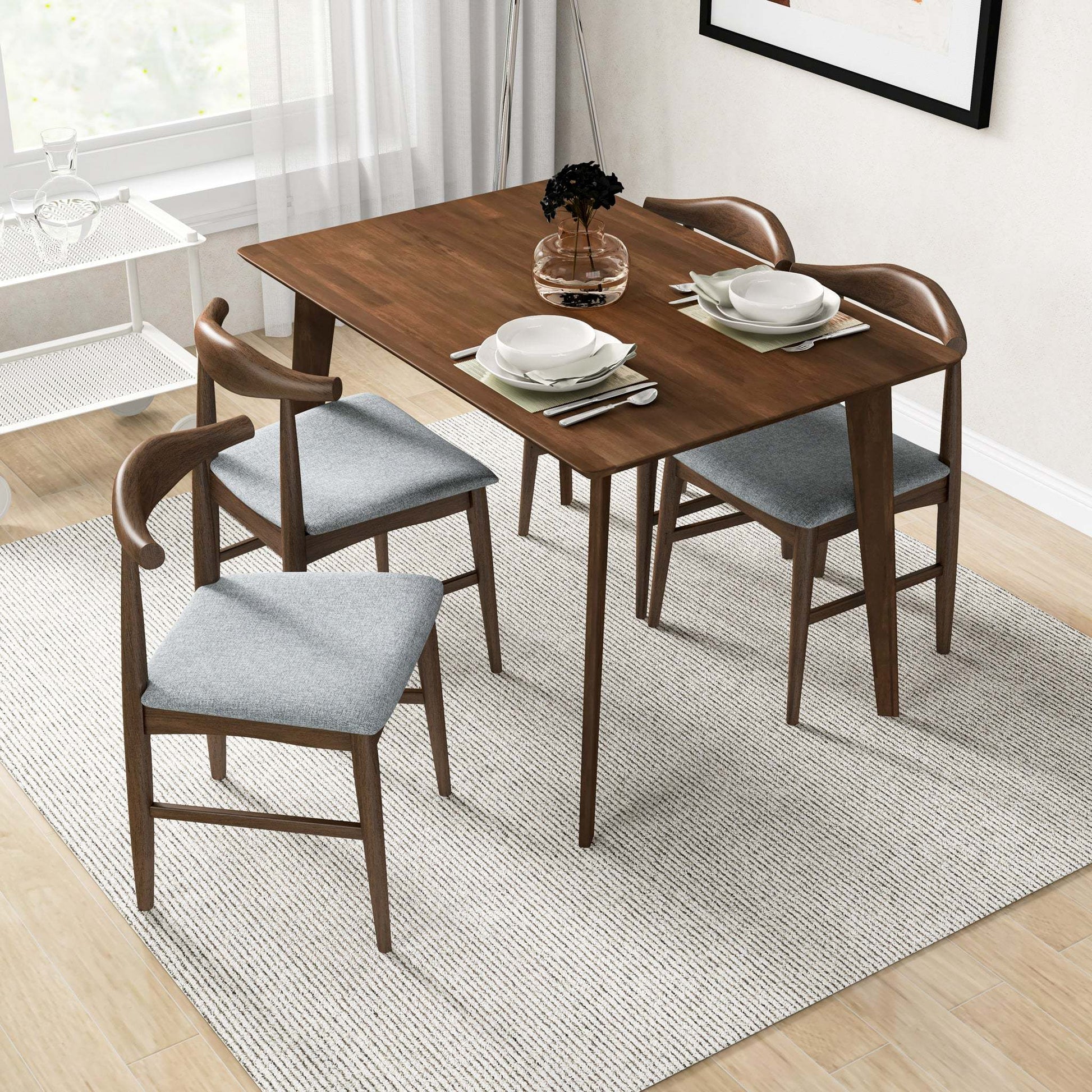 Modern wooden dining table with four grey cushioned chairs in bright home interior