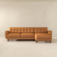 Mid-century modern tan leather sectional sofa with tufted back, displayed in a minimal room