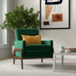 Modern living room with green mid-century armchair, yellow pillow, houseplant, and abstract wall art