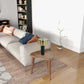 Modern living room with beige sofa, decorative pillows, wood side table and brass table lamp
