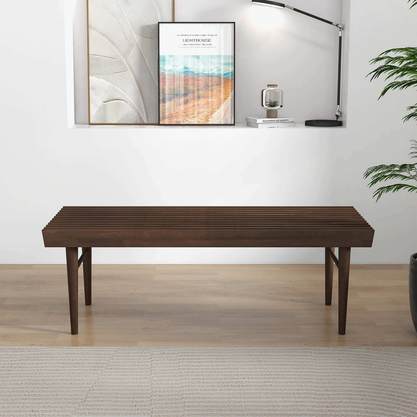 Modern wood slat bench in a minimalist living room with art, books, and a plant