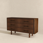 Modern dark wood dresser with three drawers, black handles, and fluted front design