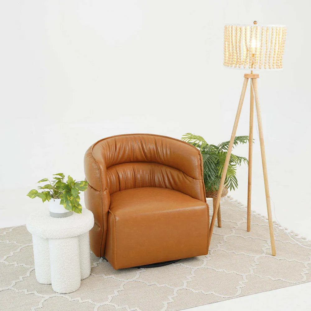 Modern tan accent chair with white side table, floor lamp, and plants on a beige rug