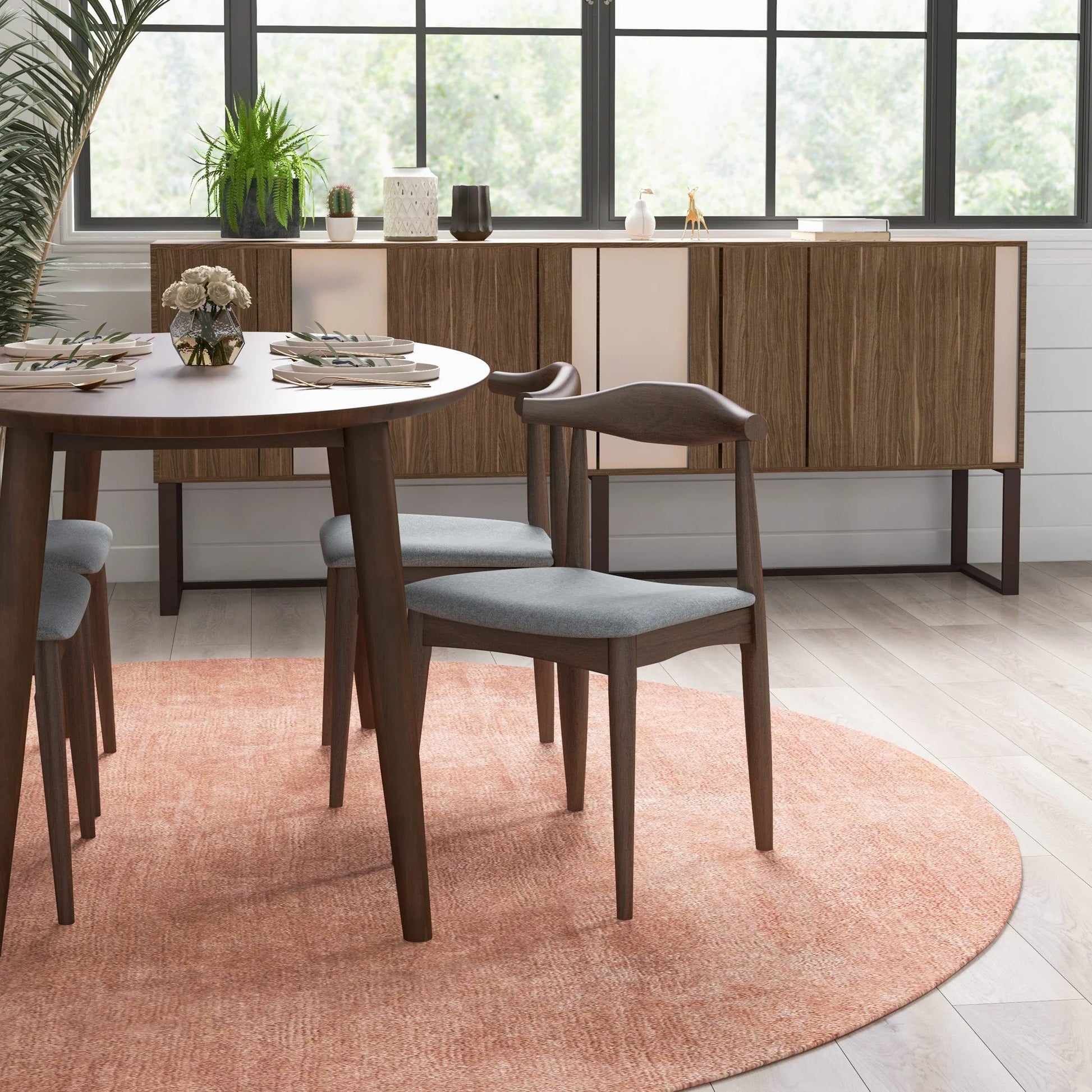 Modern dining room with wood table, gray chairs, sideboard, and pink rug from FredCo International