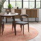 Modern dining room with wood table, gray chairs, sideboard, and pink rug from FredCo International
