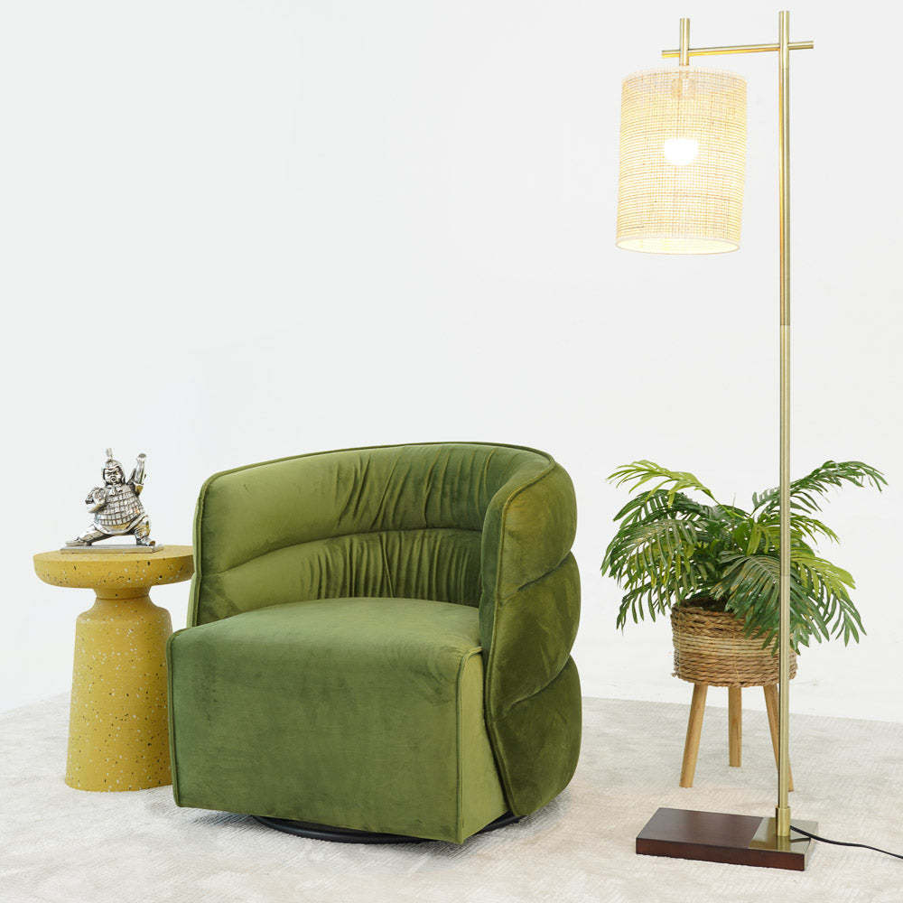 Modern green velvet accent chair with yellow side table, floor lamp, and potted plant