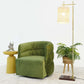Modern green velvet accent chair with yellow side table, floor lamp, and potted plant