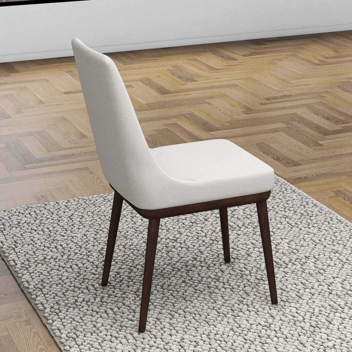 Modern beige upholstered dining chair with dark wood legs on textured rug, FredCo International furniture