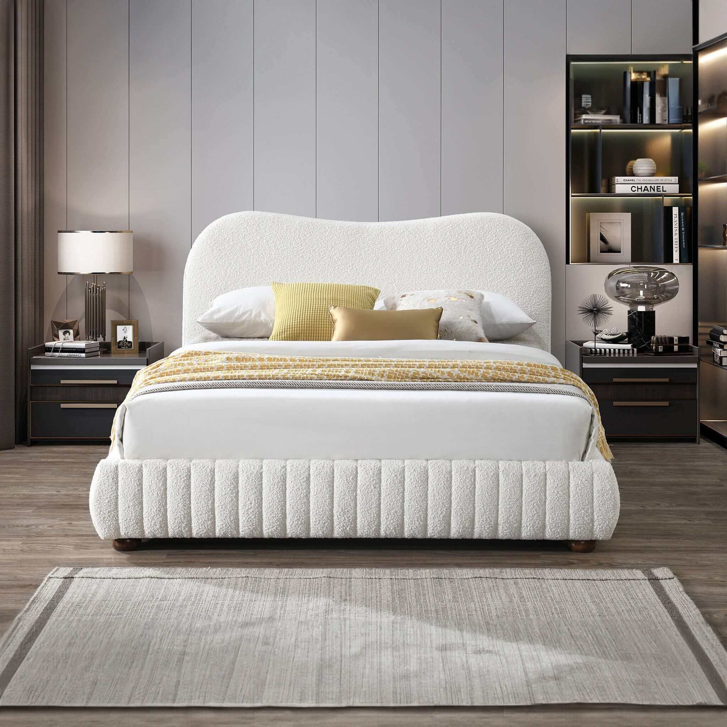 Modern bedroom with white upholstered bed, neutral decor, and stylish nightstands