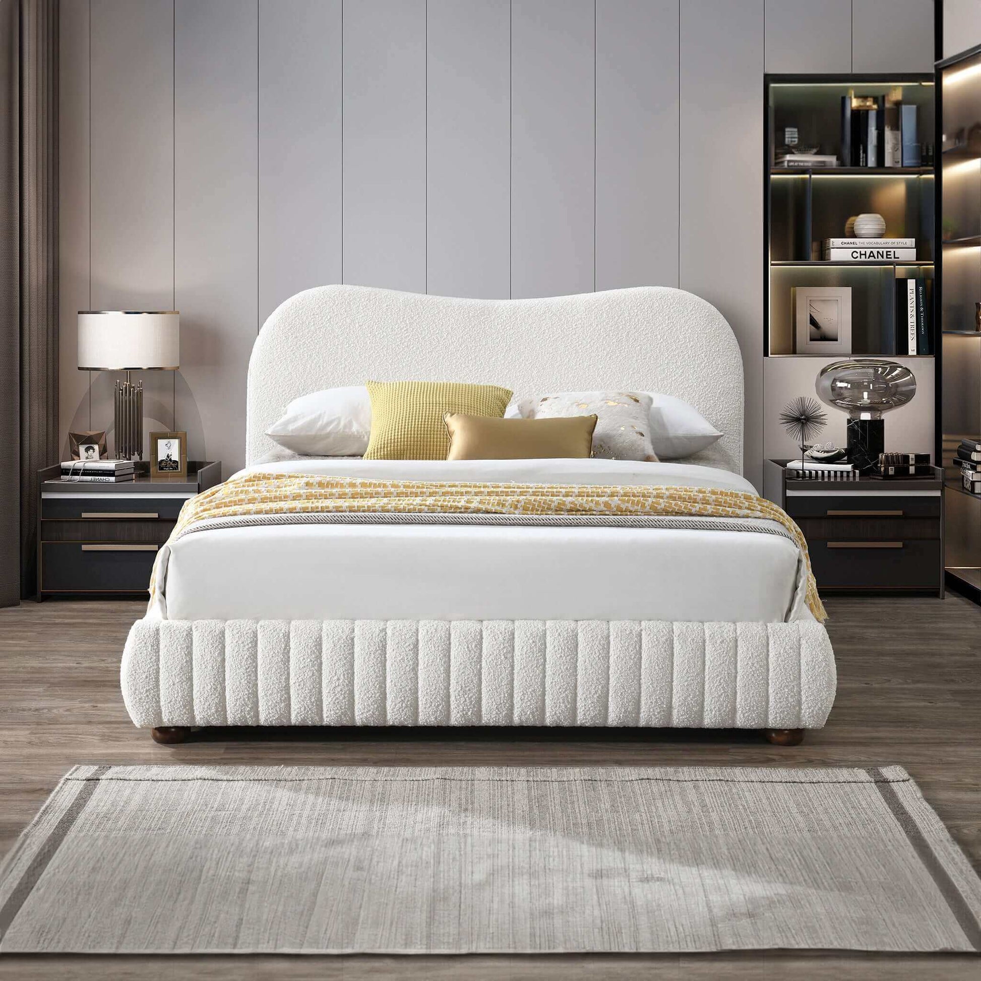 Modern bedroom with white upholstered bed, neutral decor, and stylish nightstands