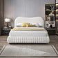 Modern bedroom with white upholstered bed, neutral decor, and stylish nightstands