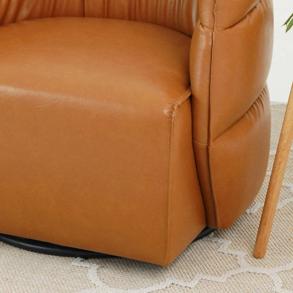Close-up of a modern tan leather armchair on a textured rug