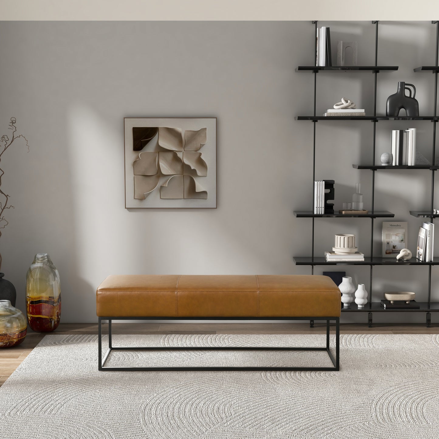 Modern living room with tan leather bench, abstract wall art, black shelf, and neutral decor