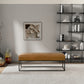 Modern living room with tan leather bench, abstract wall art, black shelf, and neutral decor