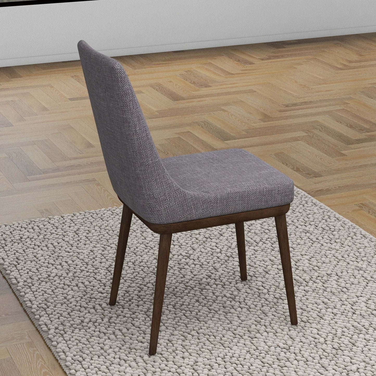 Modern gray upholstered dining chair with wooden legs on a textured rug in a stylish home setting