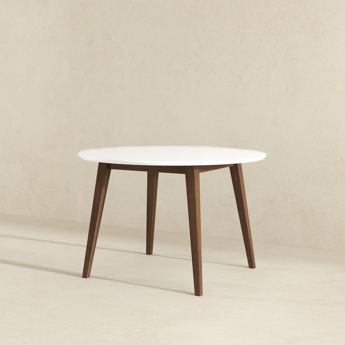 Modern round dining table with white top and wooden legs on neutral background