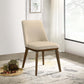 Modern beige upholstered dining chair with wooden legs in a bright, stylish living room