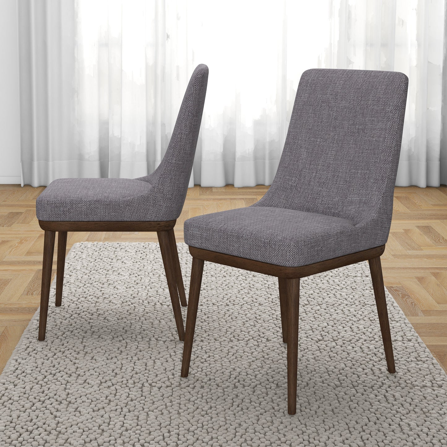 Pair of modern gray upholstered dining chairs with wooden legs on textured rug
