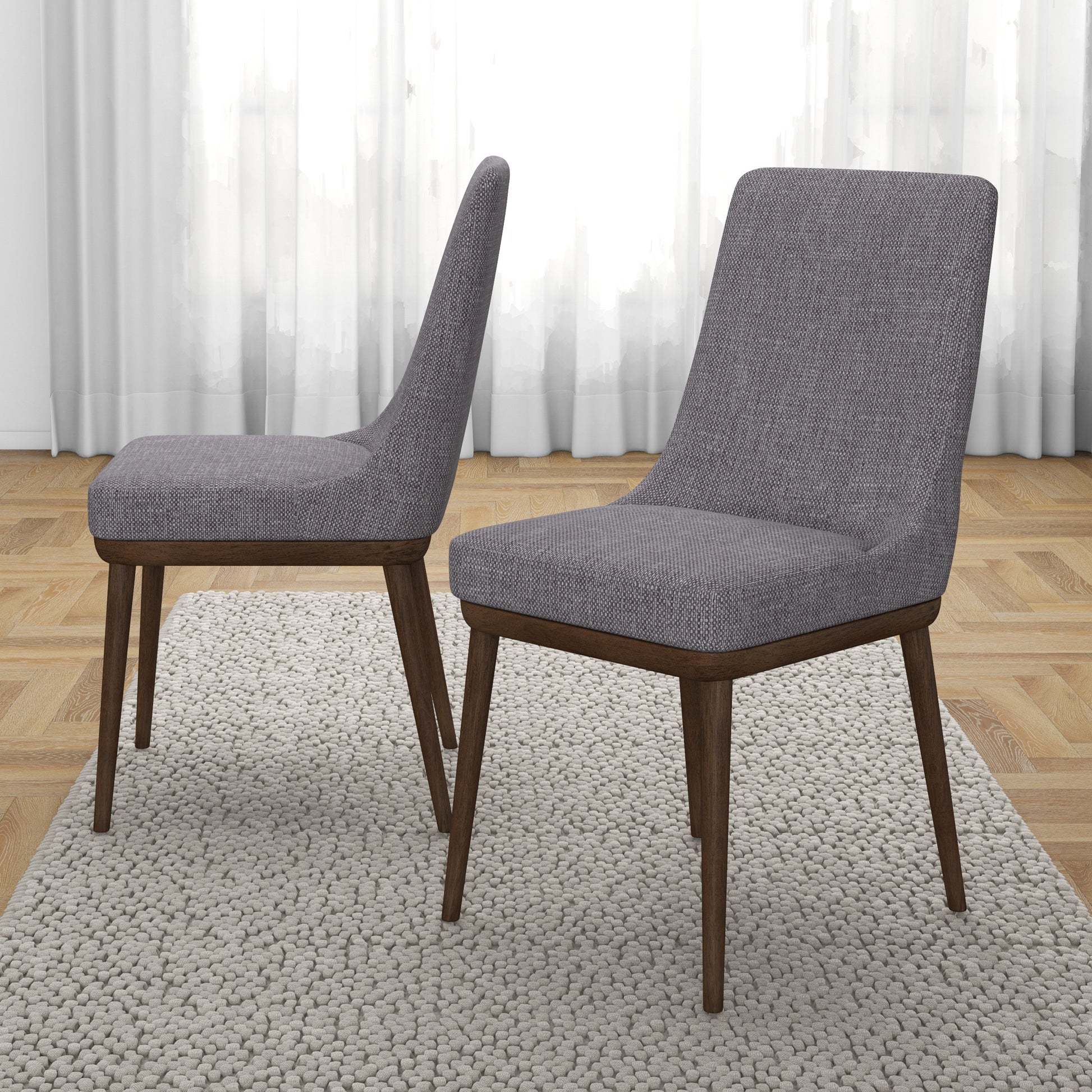 Pair of modern gray upholstered dining chairs with wooden legs on textured rug