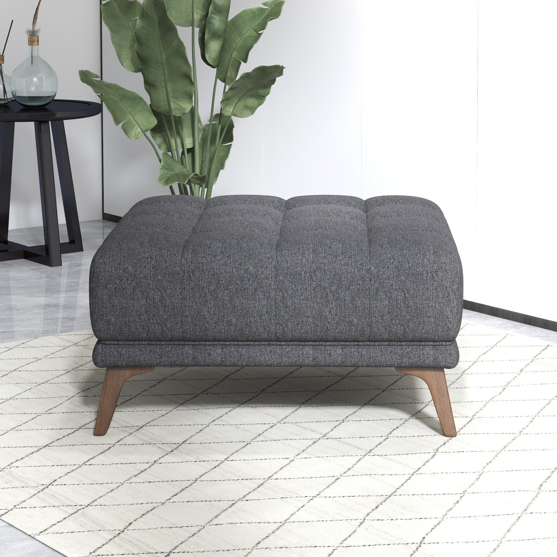 Modern gray upholstered ottoman with wooden legs on a patterned rug in a stylish living room