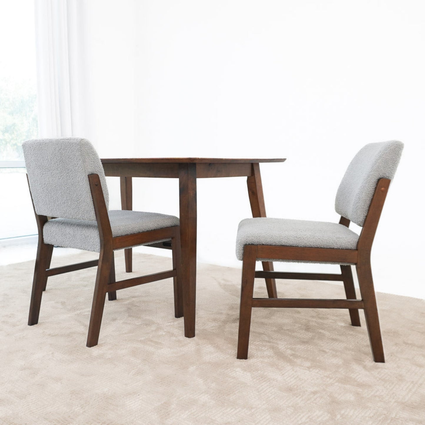 Modern dining set with dark wood table and two gray upholstered chairs on beige carpet