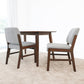Modern dining set with dark wood table and two gray upholstered chairs on beige carpet