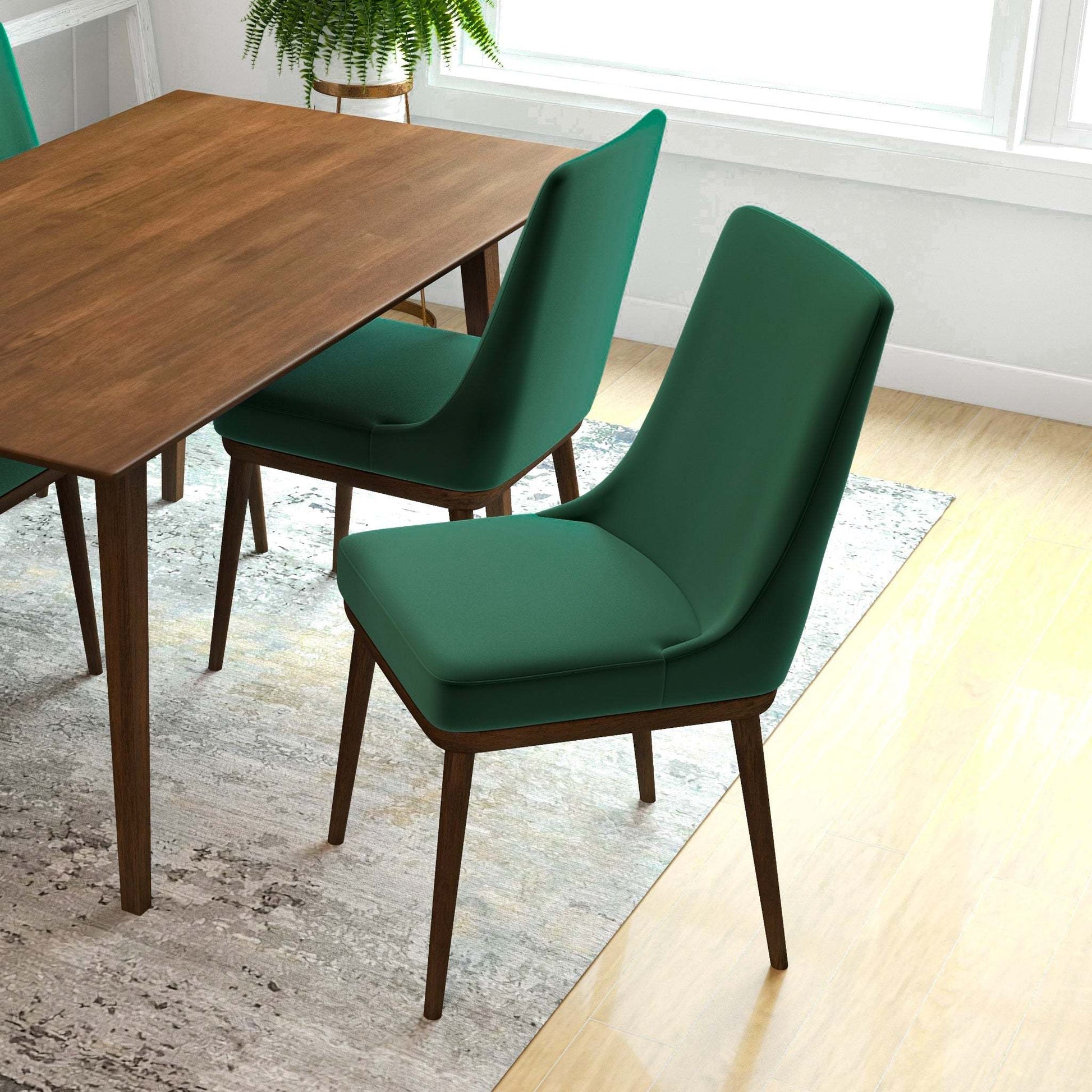 Modern green dining chairs with wooden legs around a wood table in a bright home setting