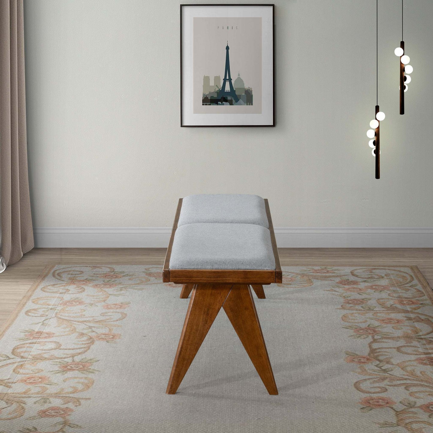 Modern wooden bench with gray cushion on floral rug, wall art and pendant lights in living room