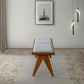 Modern wooden bench with gray cushion on floral rug, wall art and pendant lights in living room