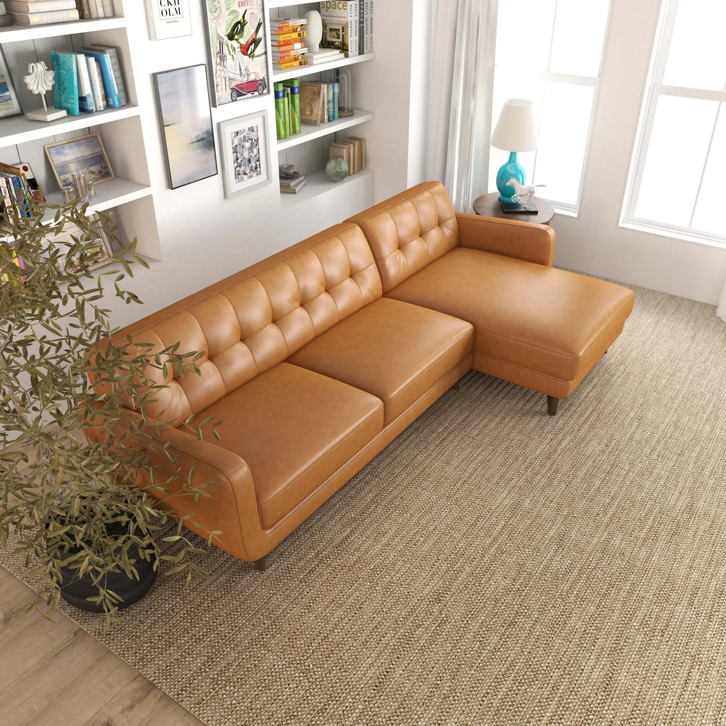 Modern tan leather sectional sofa in stylish living room with bookshelf, rug, and natural light