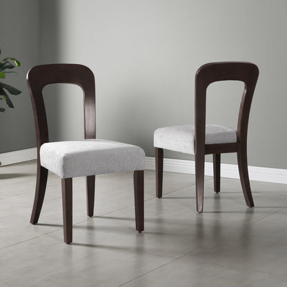 Modern dining chairs with dark wood frames and light gray upholstered seats in a minimal room