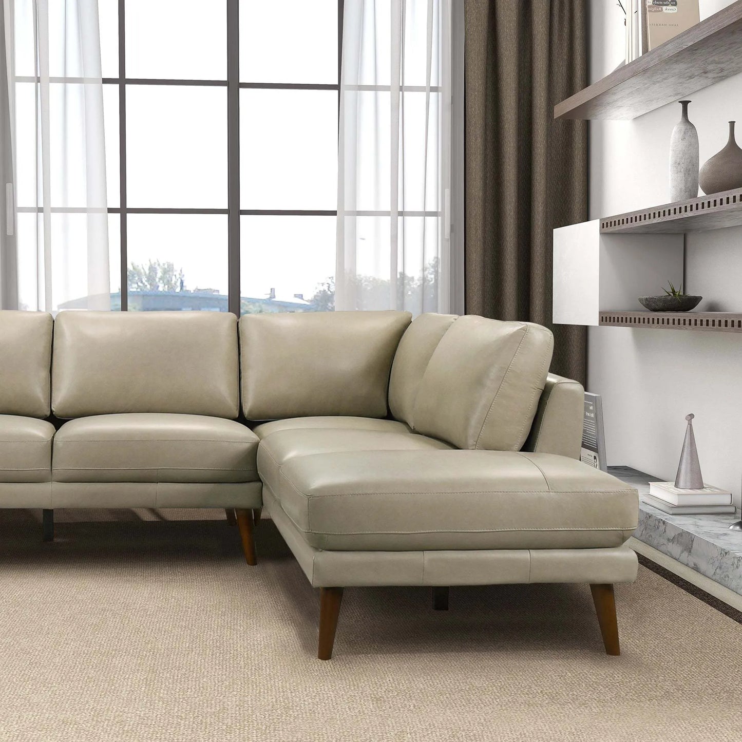 Modern beige sectional sofa in bright living room with large windows, FredCo International