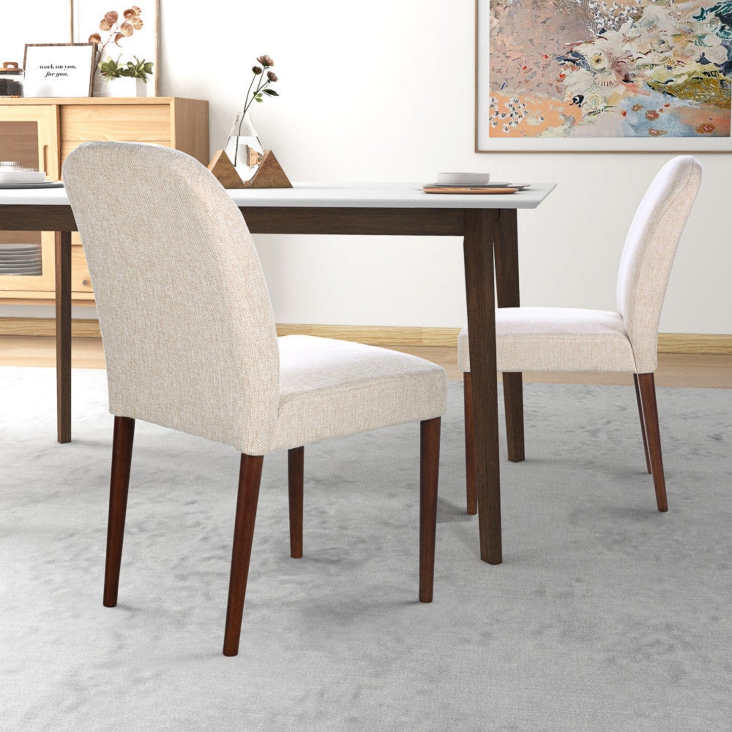 Modern beige upholstered dining chairs with dark wood legs at a dining table, FredCo International furniture
