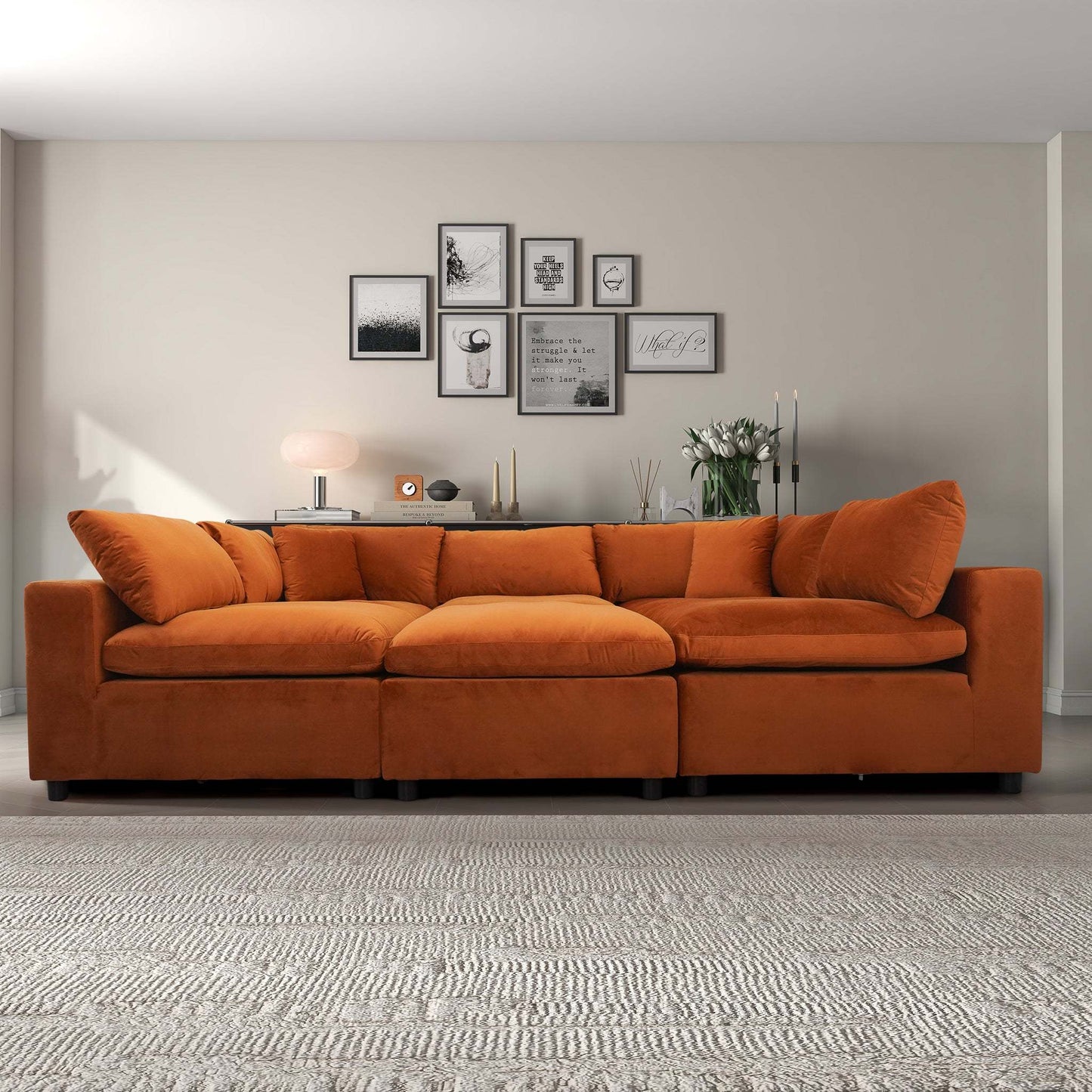 Modern living room with orange velvet sofa, gallery wall art, and neutral decor from FredCo International furniture store