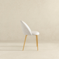 Modern white upholstered accent chair with gold legs on neutral background, FredCo International