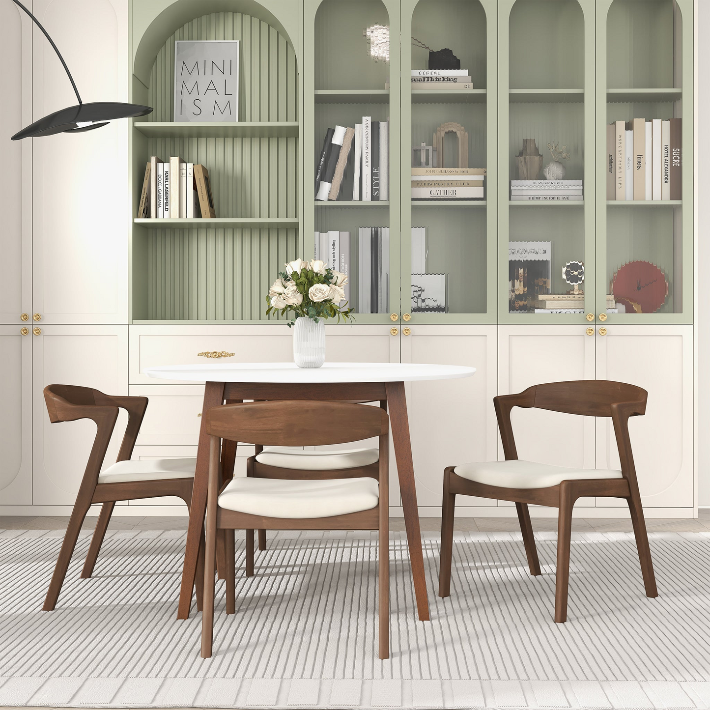 Modern dining room with round white table, wooden chairs, vase of flowers, and stylish bookcase
