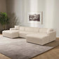 Modern beige sectional sofa in a stylish living room with neutral rug and abstract wall art