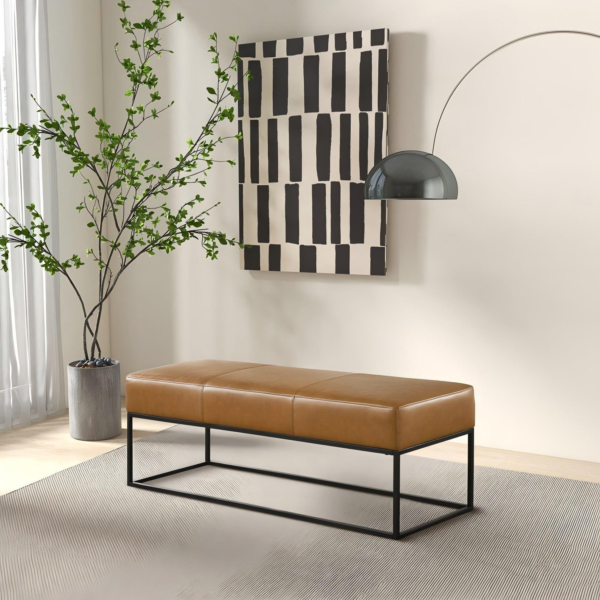 Modern tan leather bench with black metal frame in a minimalist living room, art and plant decor