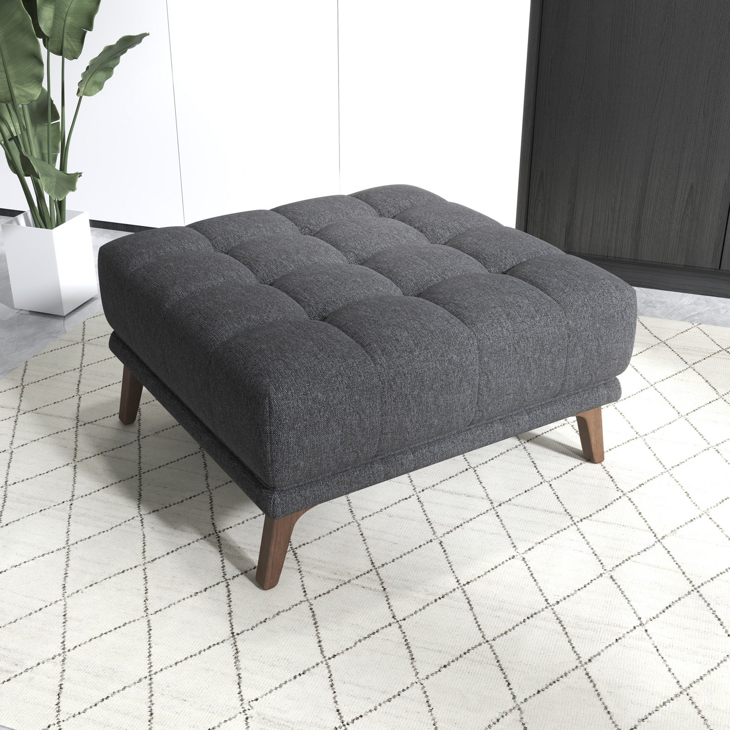 Modern dark gray upholstered ottoman with wooden legs on a patterned rug in a stylish living room
