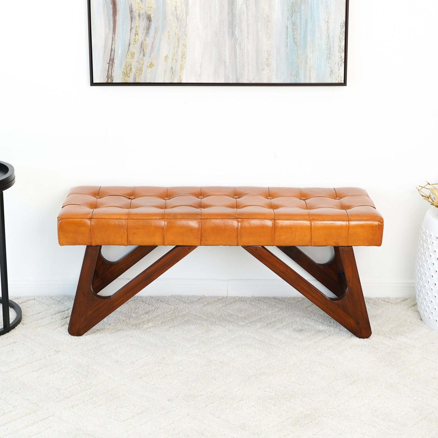 Mid-century modern tan leather bench with tufted cushion and wood base in stylish living room