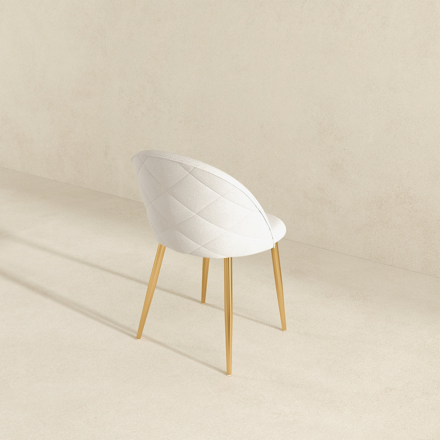Modern white upholstered chair with gold legs on a beige background, FredCo International furniture