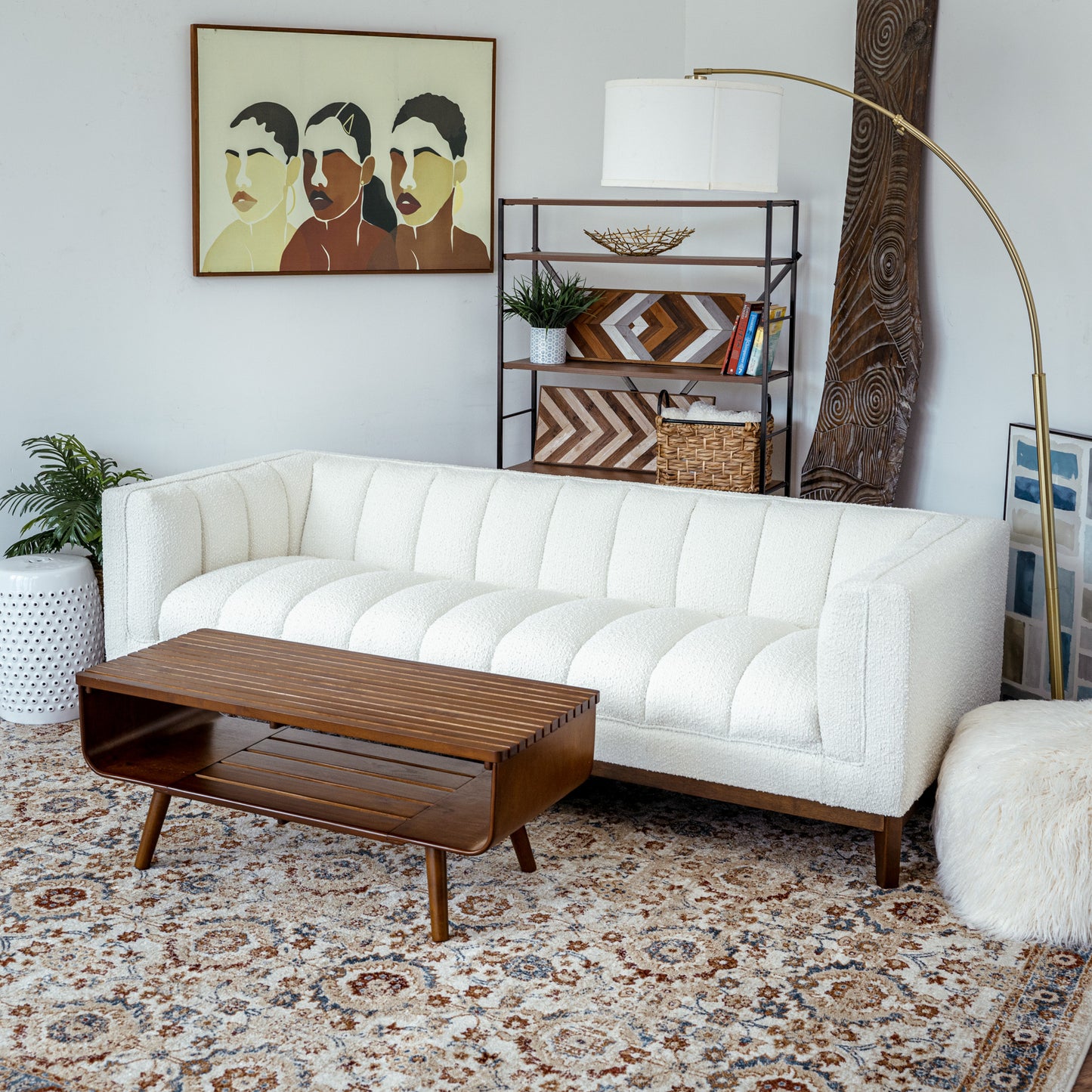 Modern living room with white sofa, wooden coffee table, and decorative shelf from FredCo International