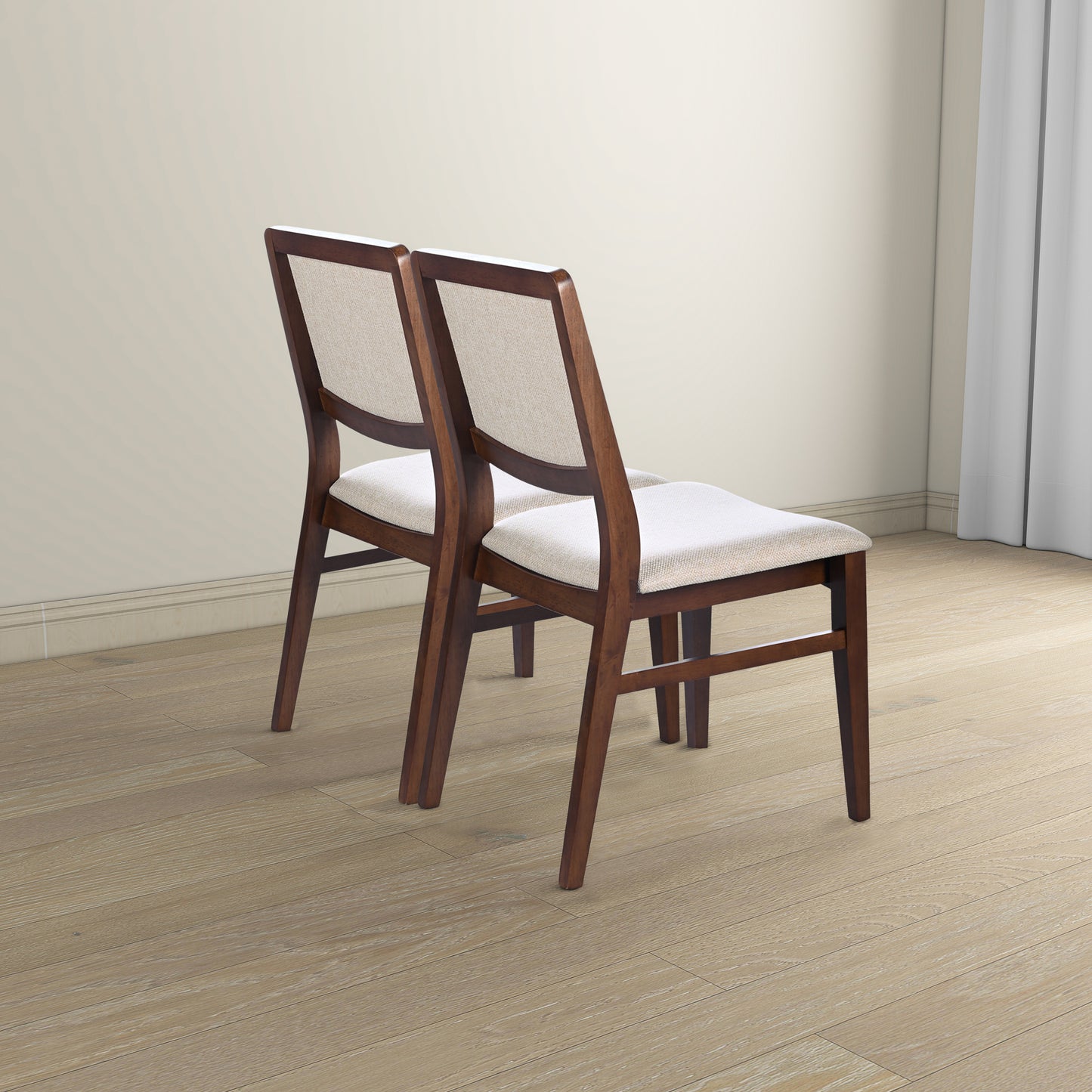 Pair of modern wooden dining chairs with beige upholstery on light wood floor