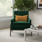 Modern green armchair with gold pillow in cozy living room, beside coffee table and indoor plant